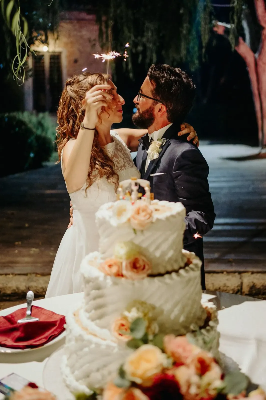 Gli sposi si imboccano con la torta nuziale durante la festa serale