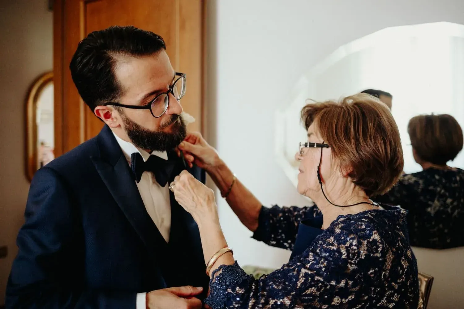 La madre appunta il fiore all'occhiello dello sposo