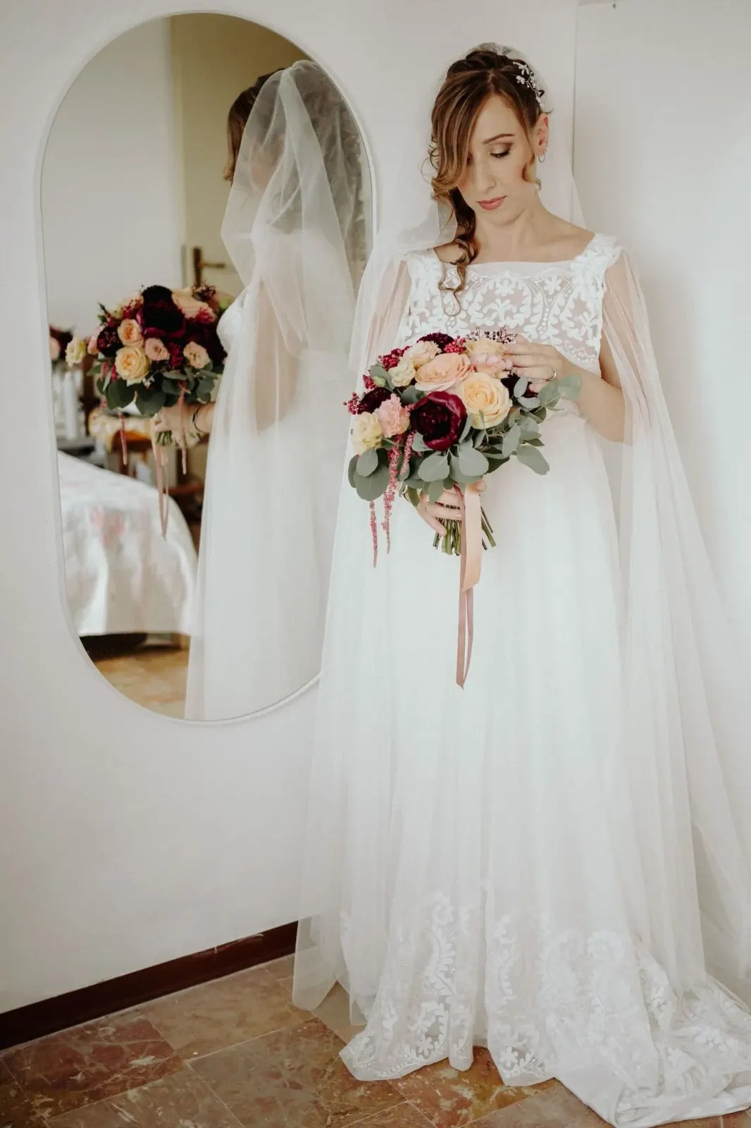 La sposa con il bouquet davanti allo specchio