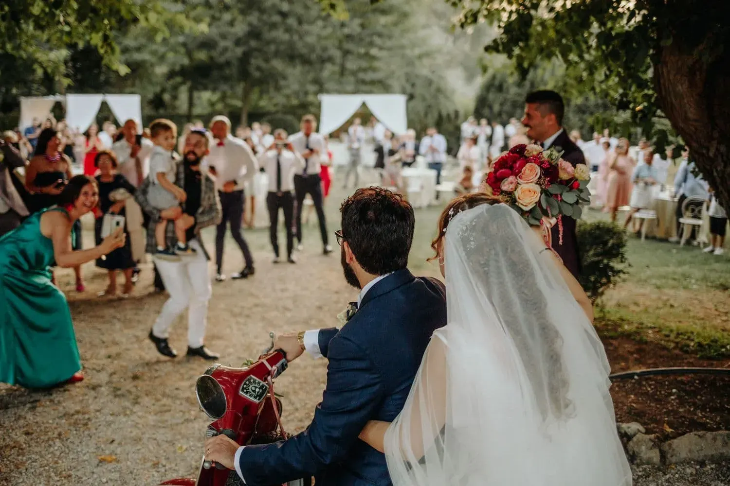 L'arrivo degli sposi in Vespa al ricevimento tra gli invitati