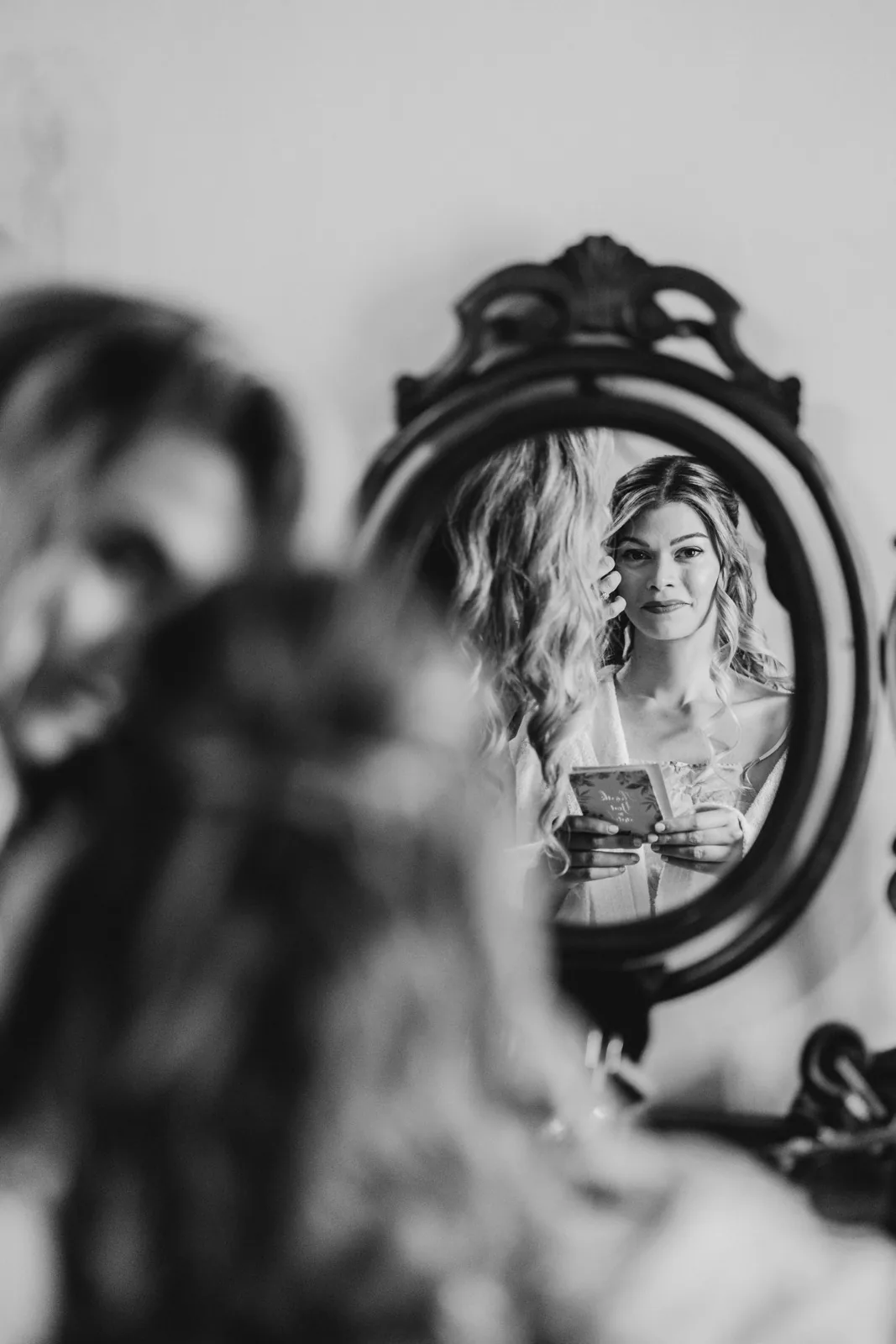 Il riflesso della sposa nello specchio durante i preparativi, in bianco e nero