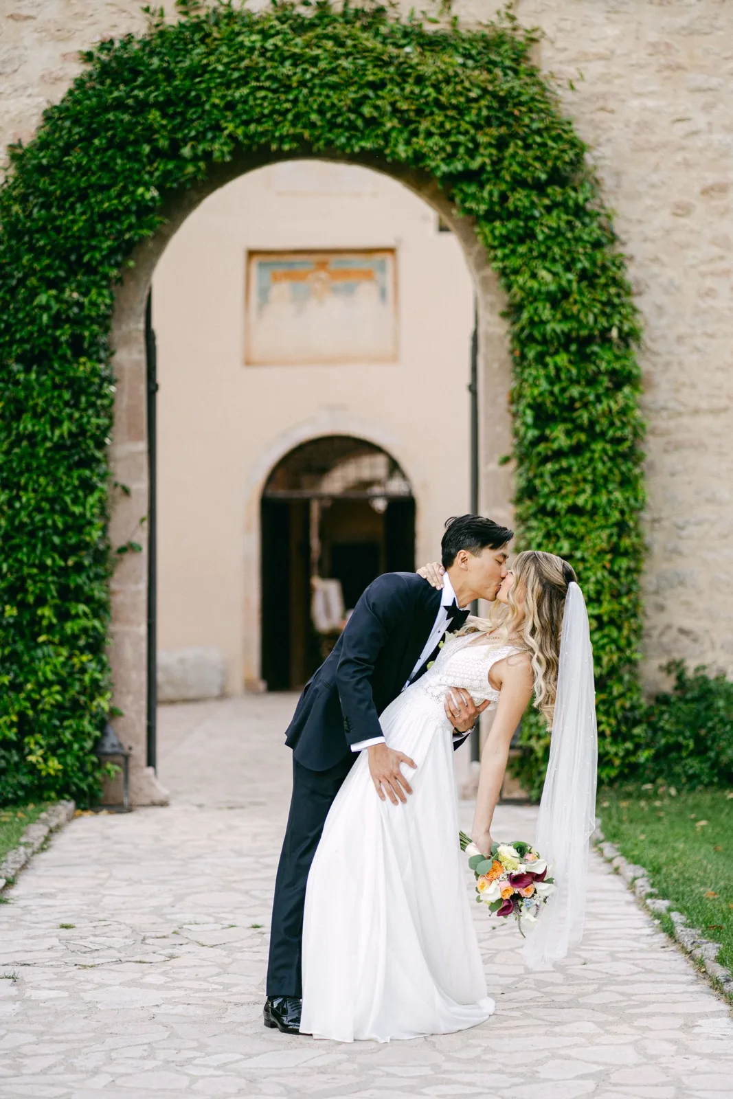 Il bacio degli sposi sotto l’arco d’edera dell’abbazia