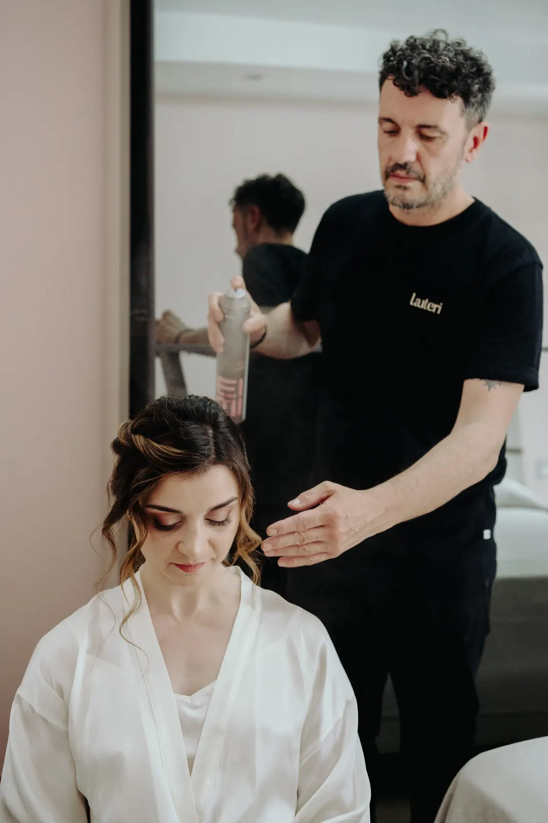 Il parrucchiere sistema l'acconciatura di Martina durante i preparativi
