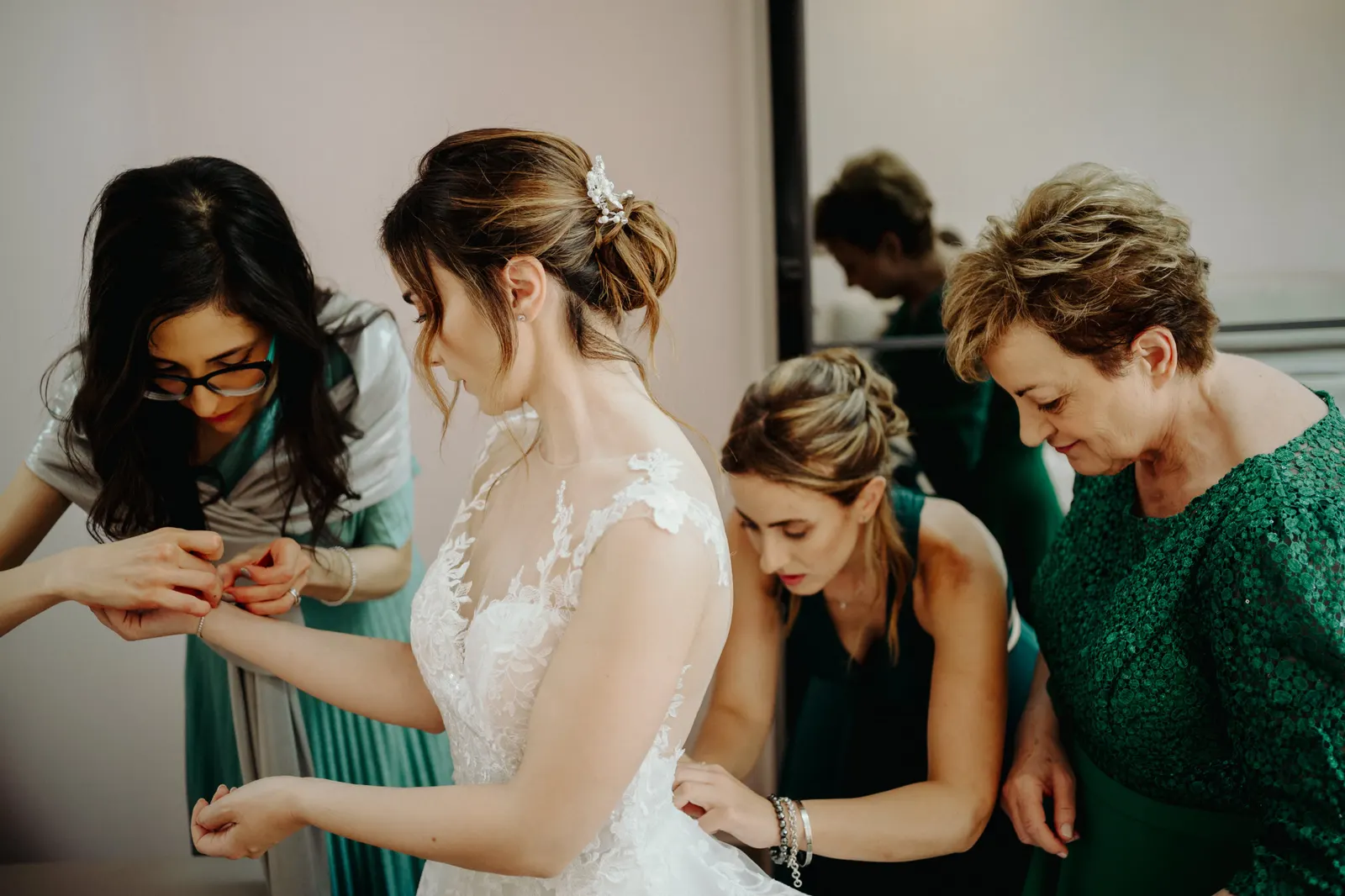 Martina indossa l'abito da sposa aiutata dalle donne che le stanno intorno