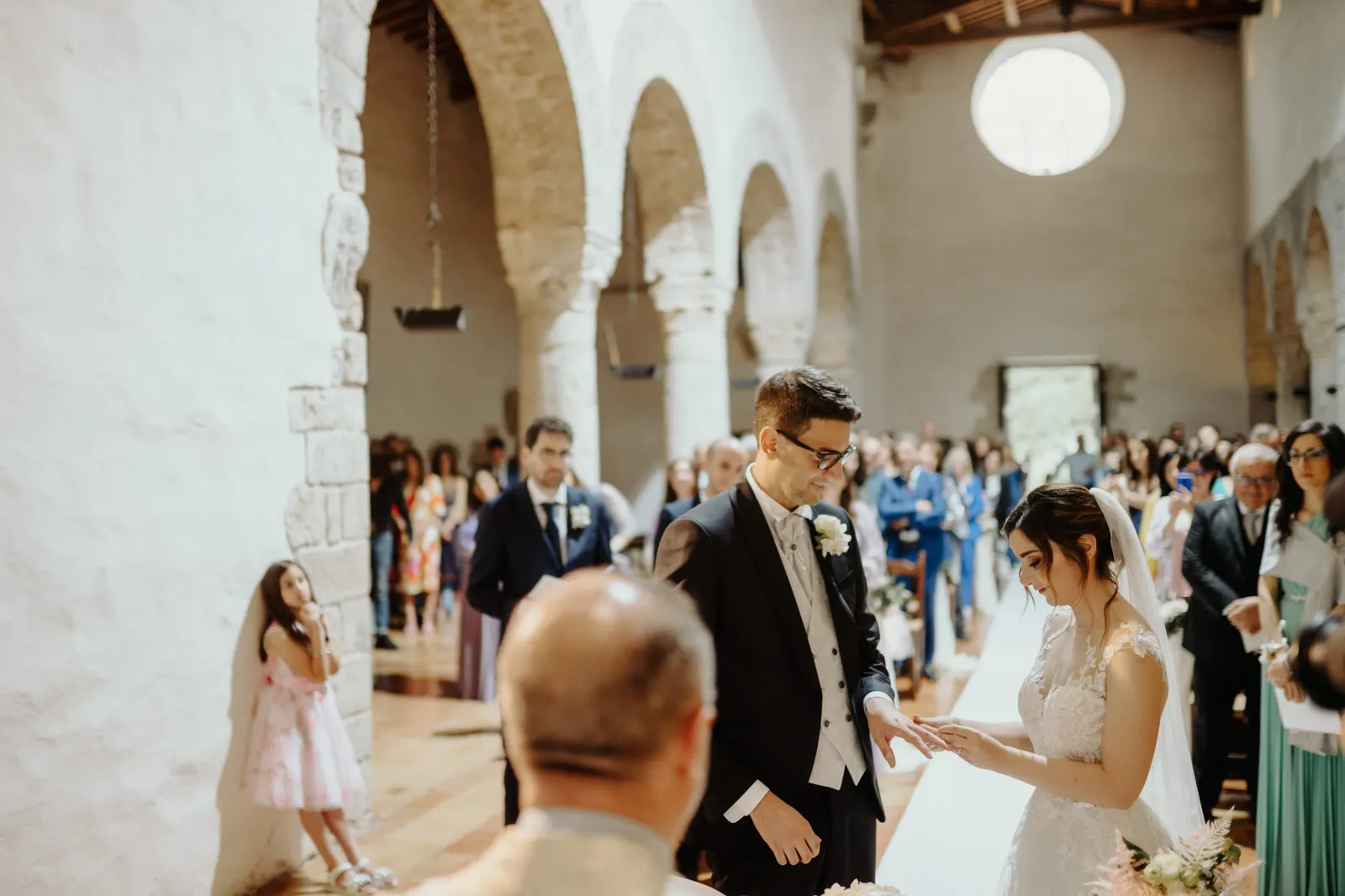 Lo scambio degli anelli tra le arcate in pietra di San Nicolò, con gli invitati alle spalle
