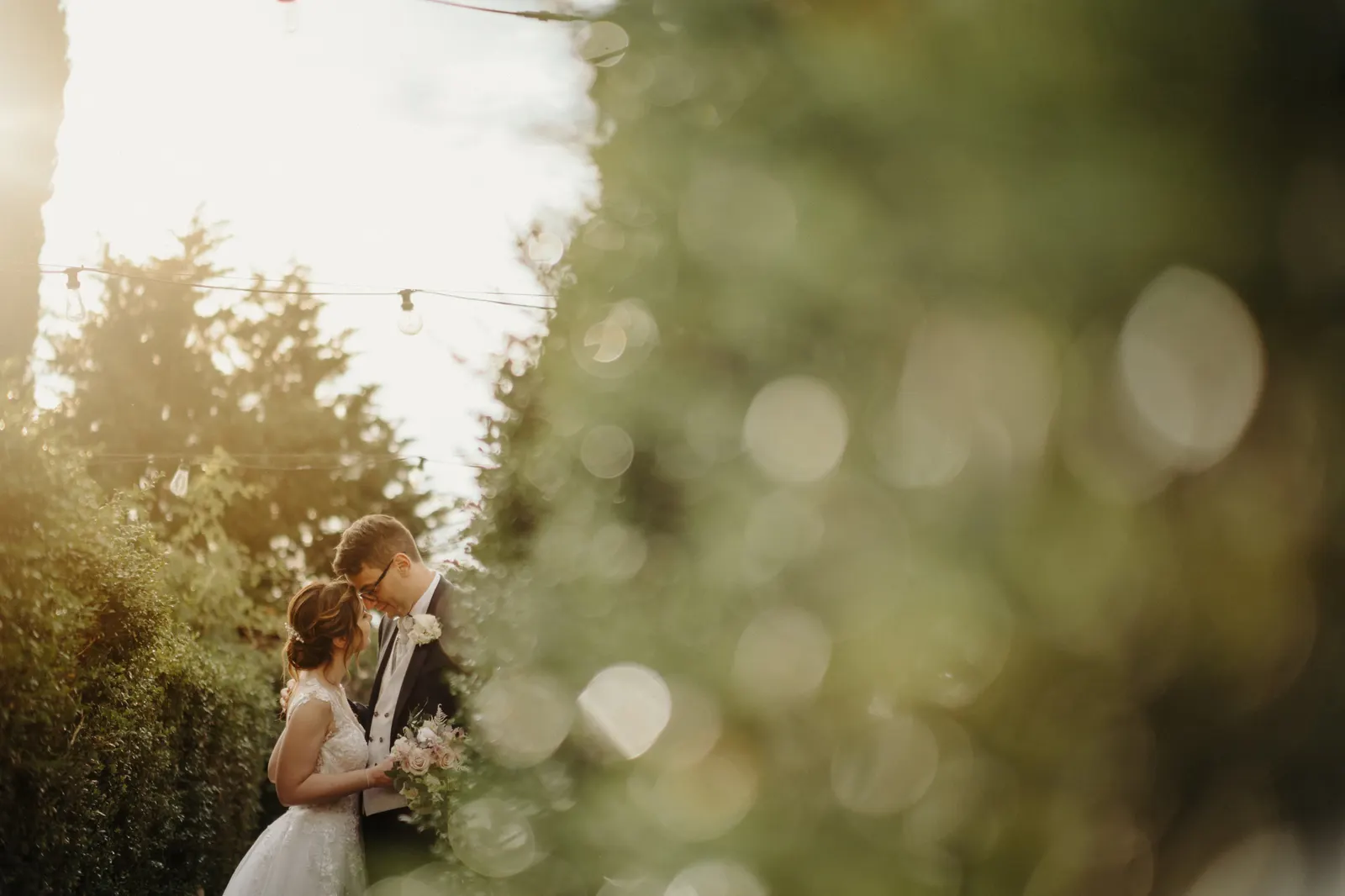 Il bacio degli sposi in controluce tra il verde del Castello di Montignano