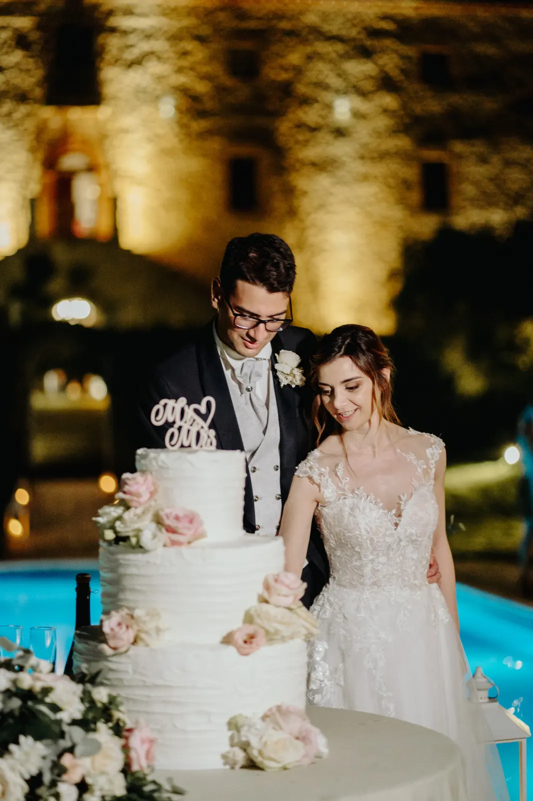 Il taglio della torta a bordo piscina, con il Castello di Montignano illuminato