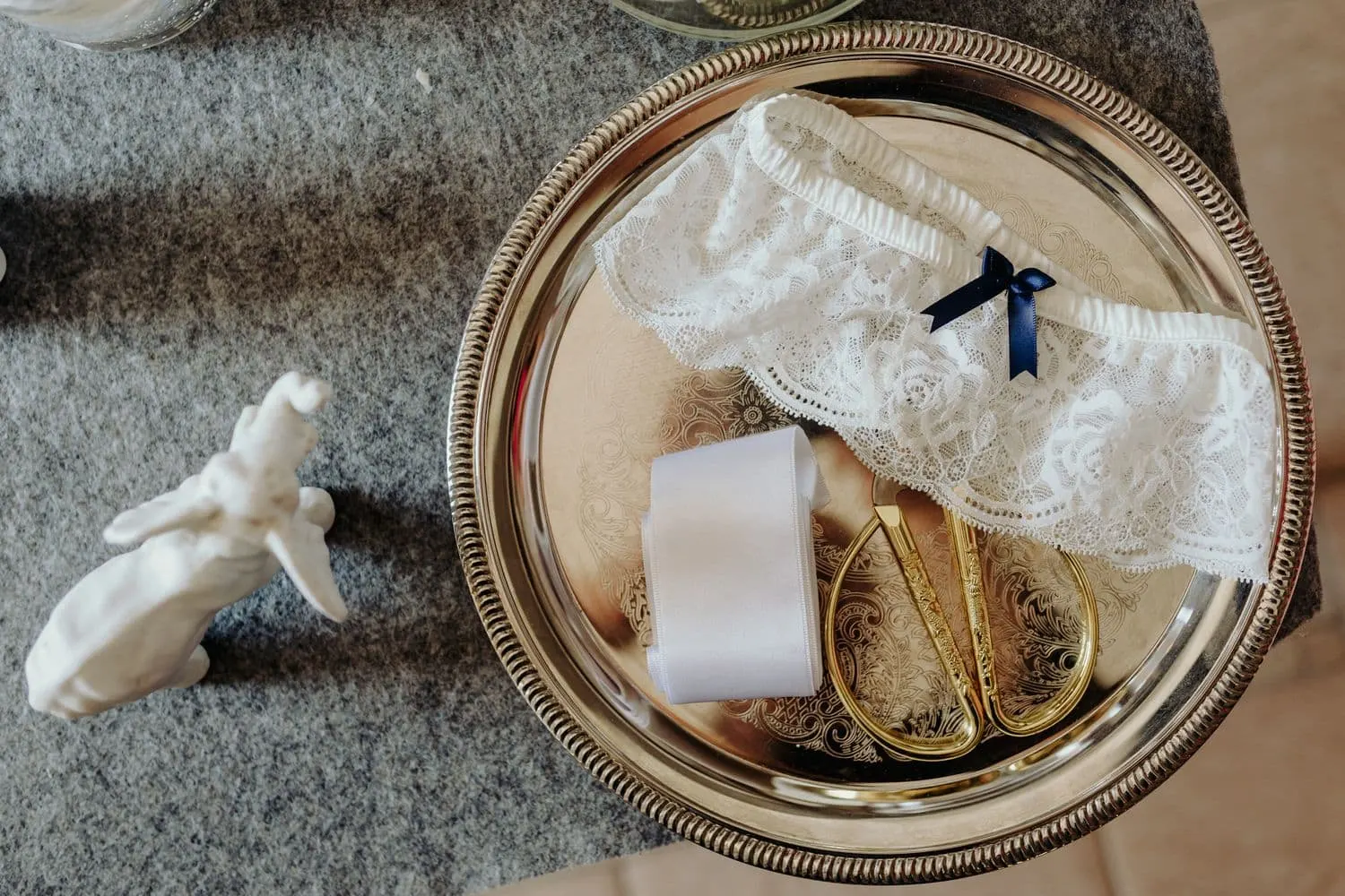 The lace garter and a pair of gold scissors on a tray