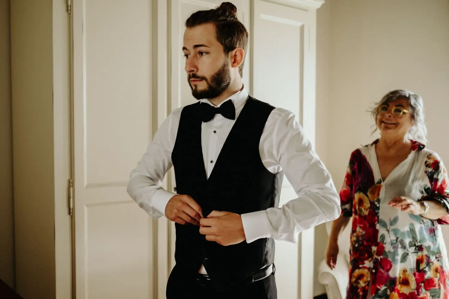 Raffaele buttoning his waistcoat while getting ready