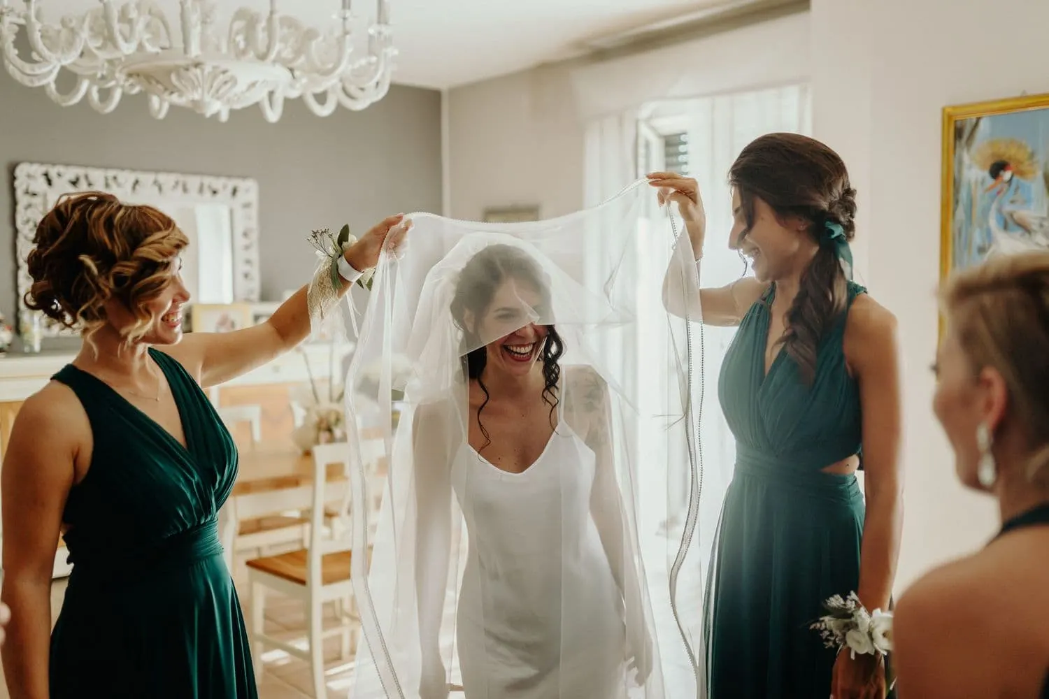 The bridesmaids arranging the veil over the bride's head