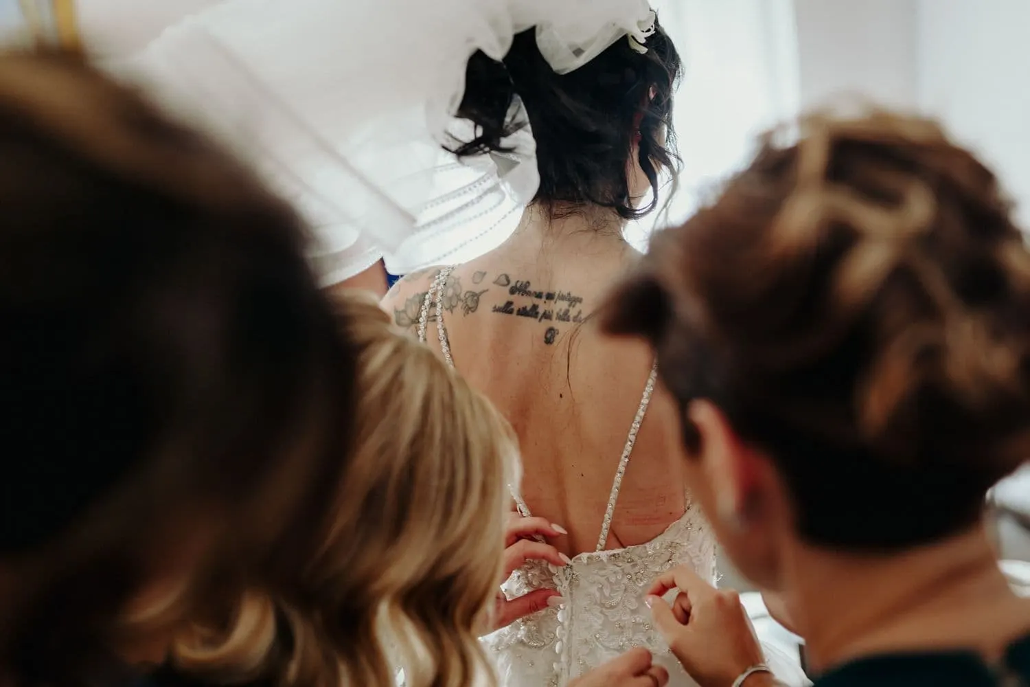 The dress being fastened at the bride's back
