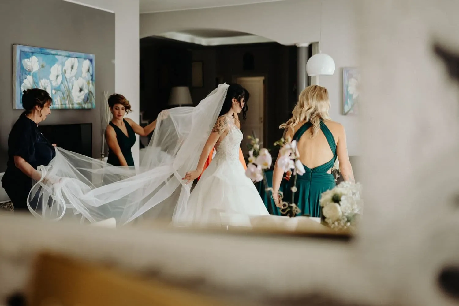 The bridesmaids spreading out Micaela's long veil in the living room