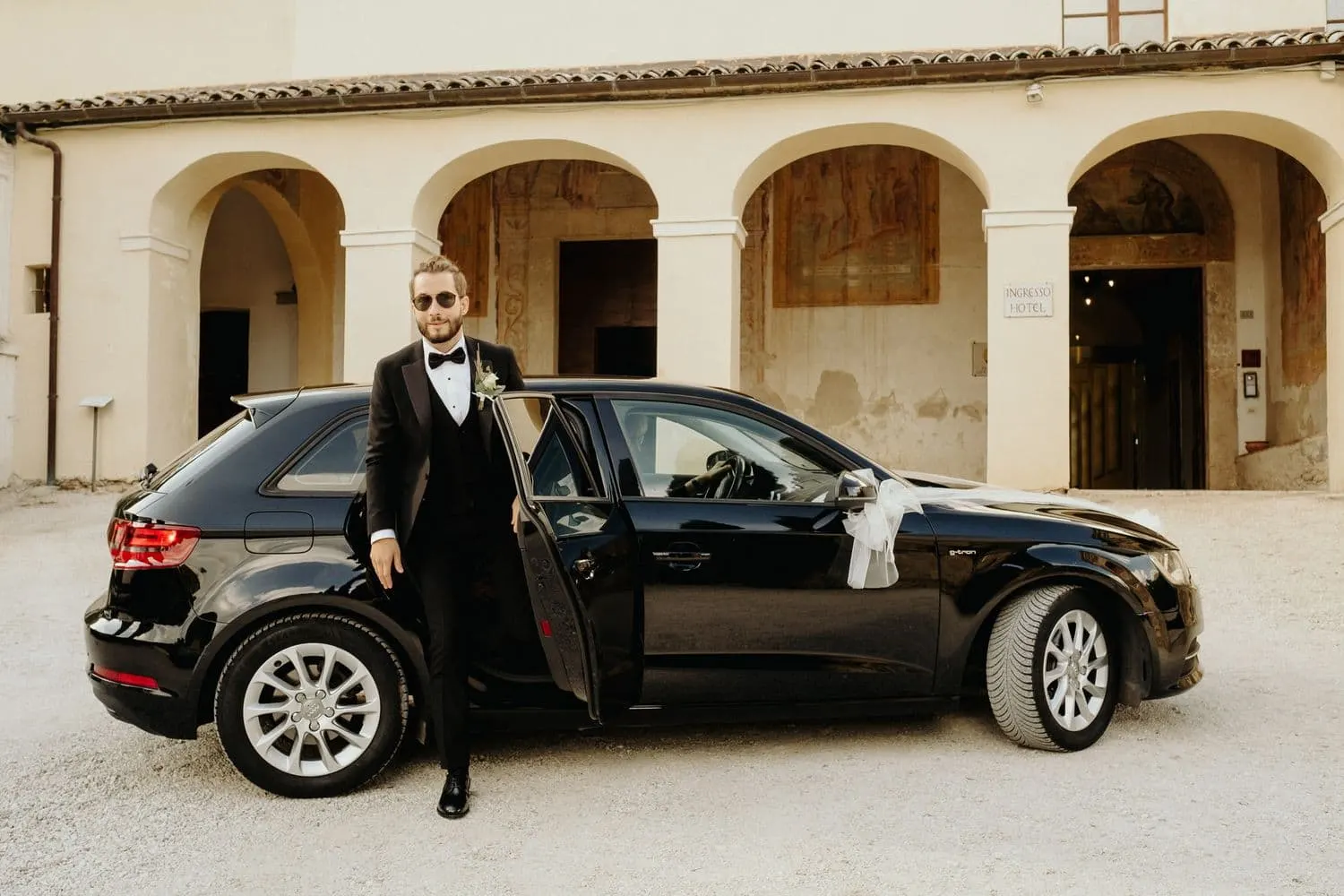 Raffaele getting out of the car in front of the portico at San Pietro Sopra le Acque