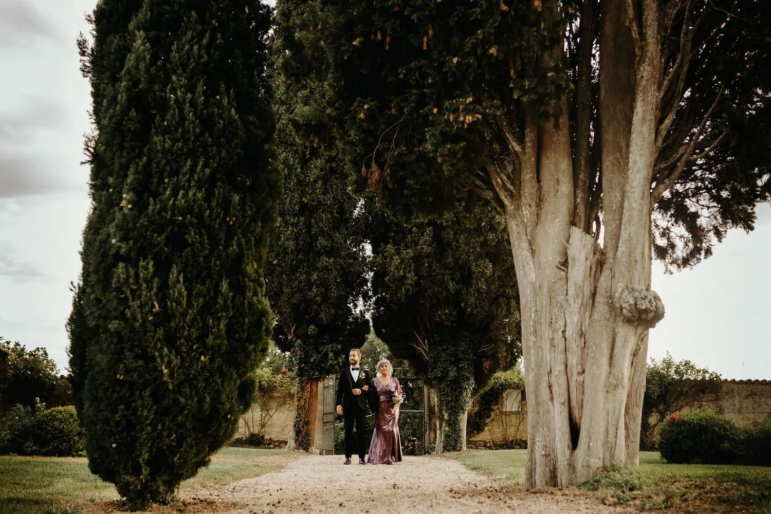 Raffaele and his mother walking down the avenue among the cypresses