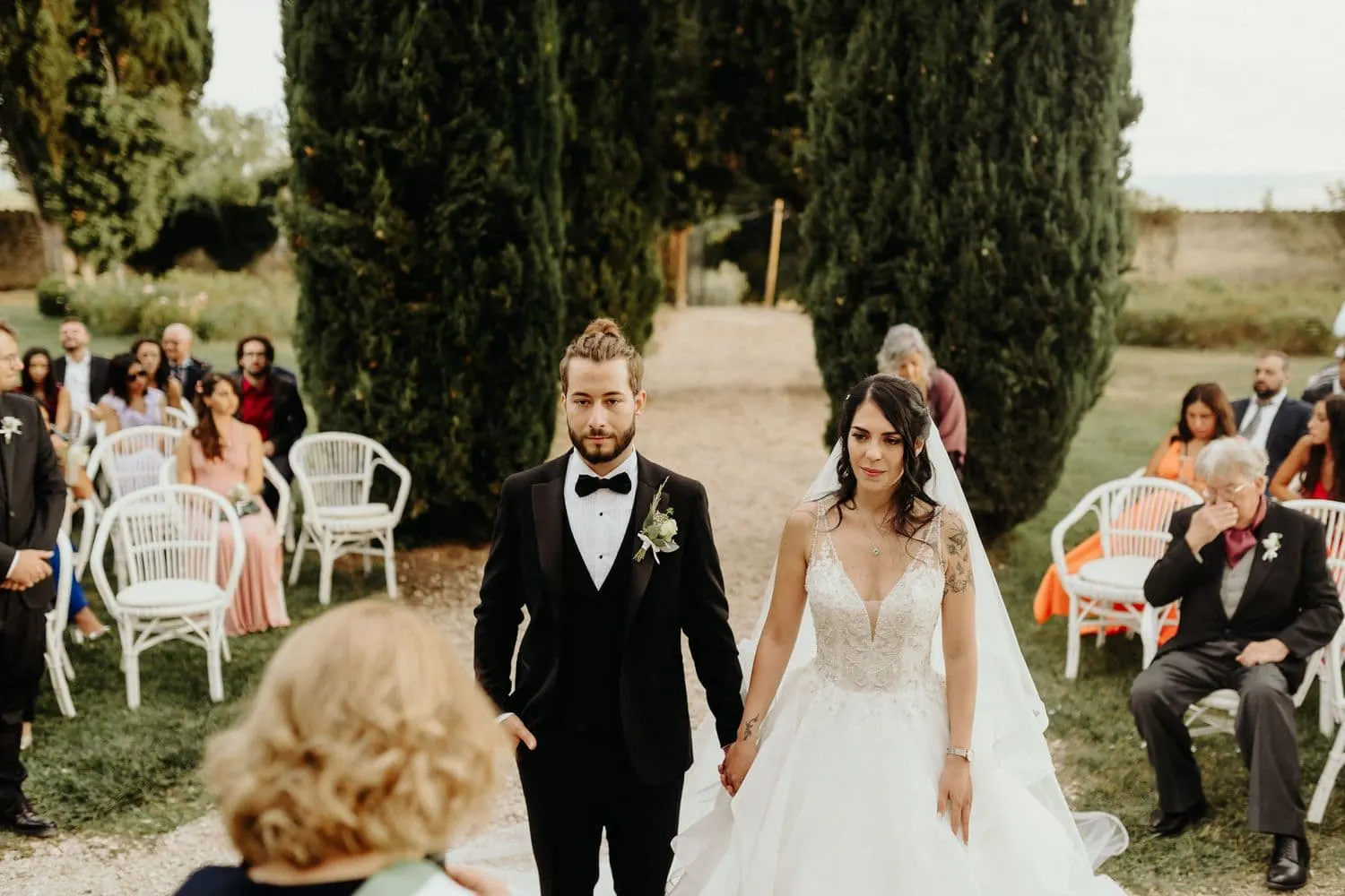 Micaela and Raffaele hand in hand in front of the guests at the start of the ceremony