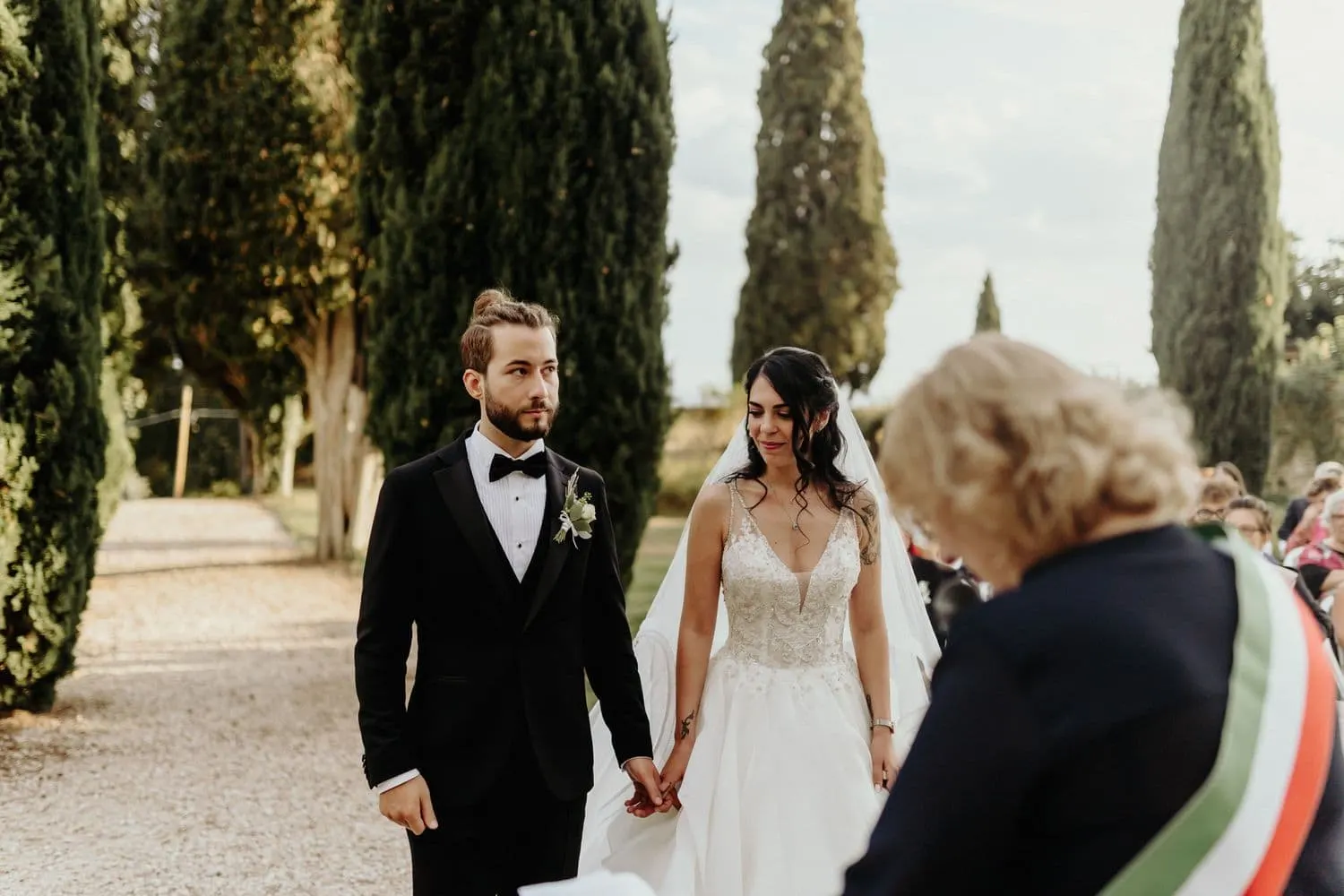 The couple in front of the officiant wearing the tricolour sash