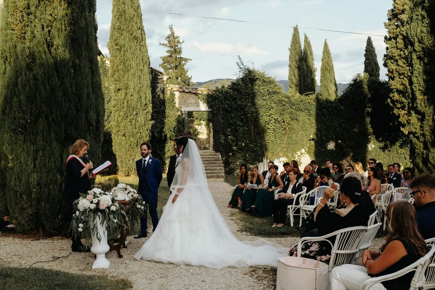 The civil ceremony in the clearing among the cypresses, with the guests seated