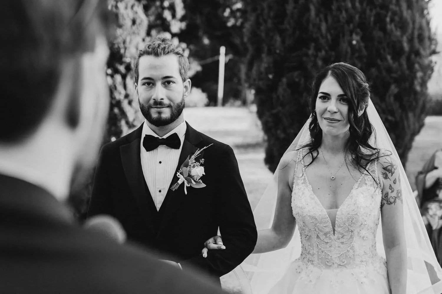 Micaela and Raffaele listening to a speech during the ceremony, in black and white