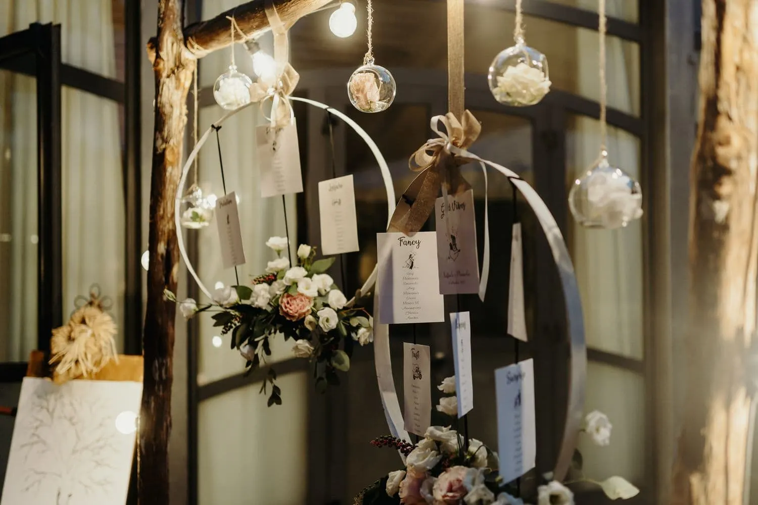 Detail of the seating plan with flowers and hanging light bulbs