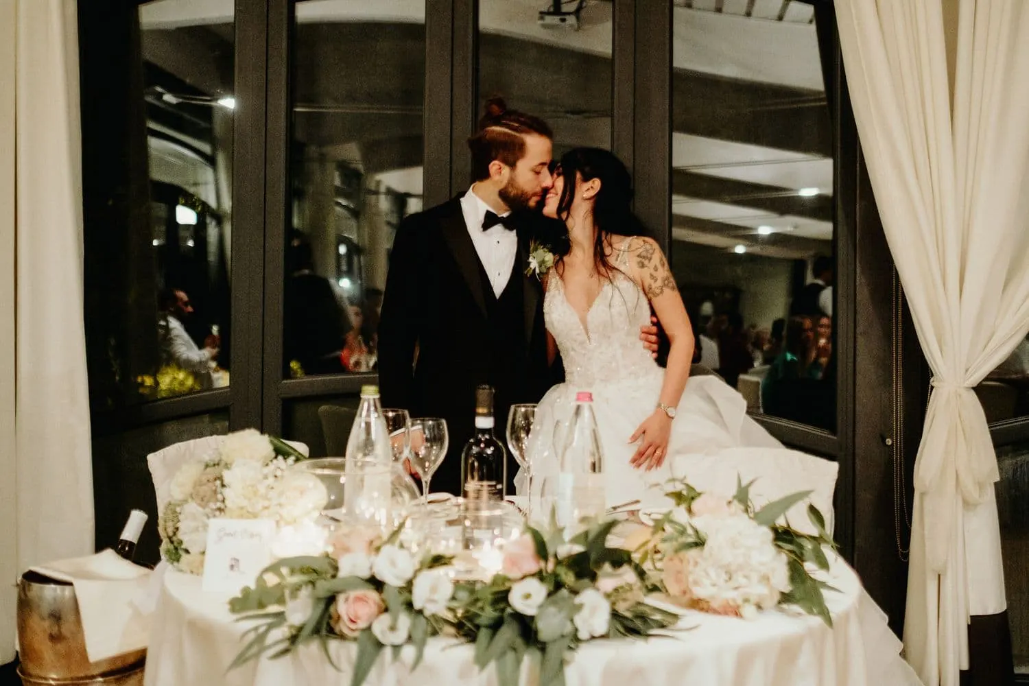 The couple kissing at their table during dinner