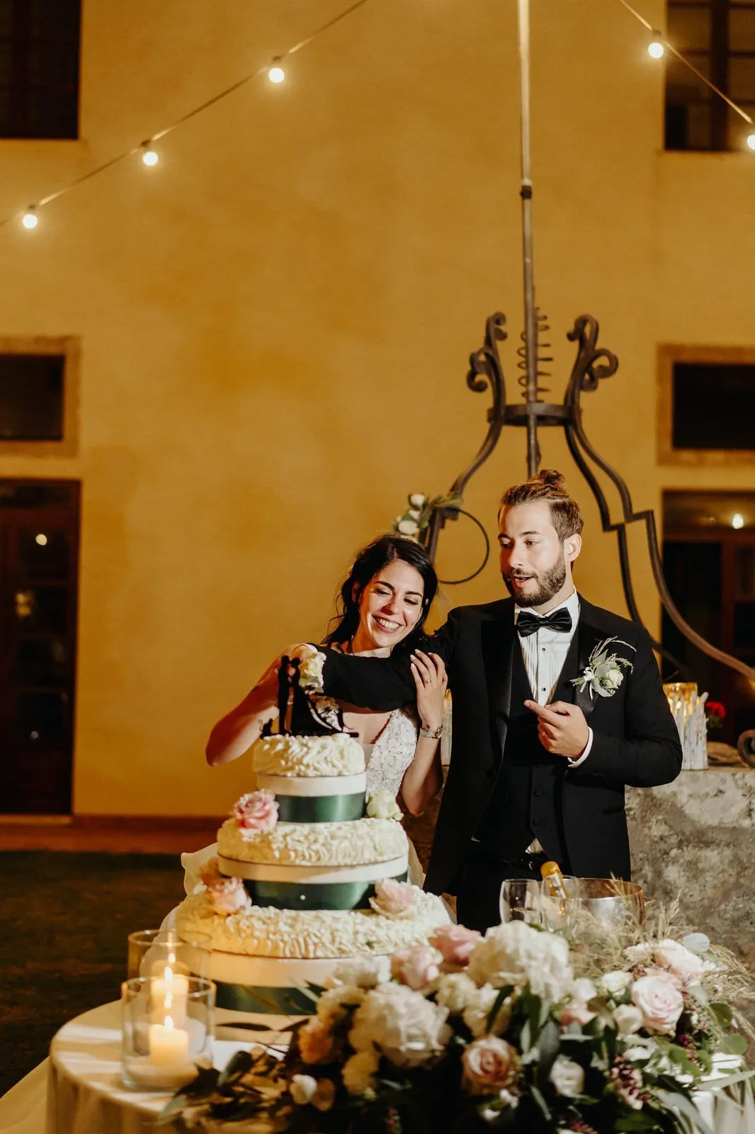 Cutting the cake outdoors under the string lights