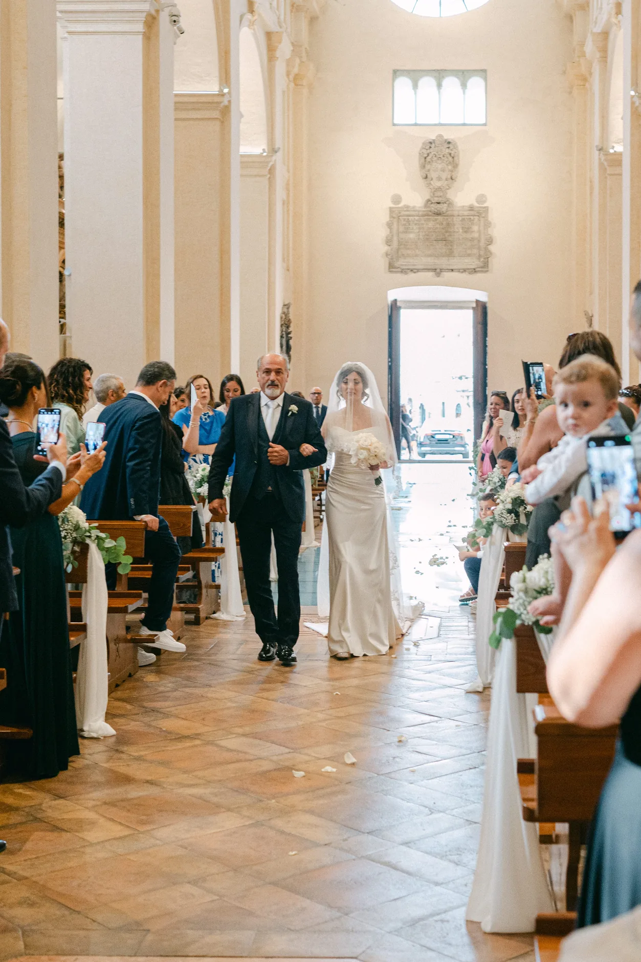 Rossella percorre la navata della Cattedrale di San Rufino tra gli invitati