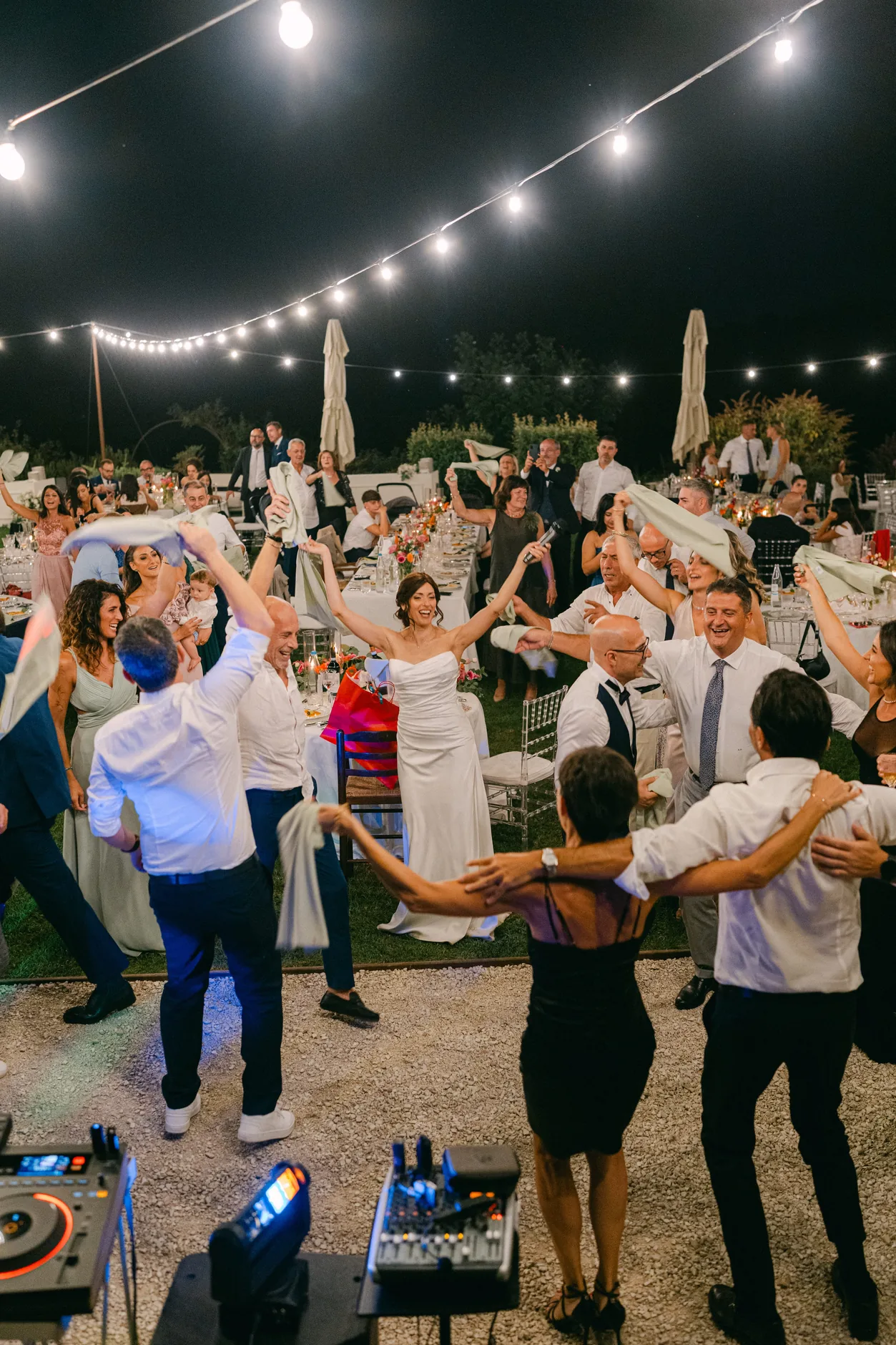 La festa sotto il cielo stellato di luci: gli invitati ballano intorno alla sposa