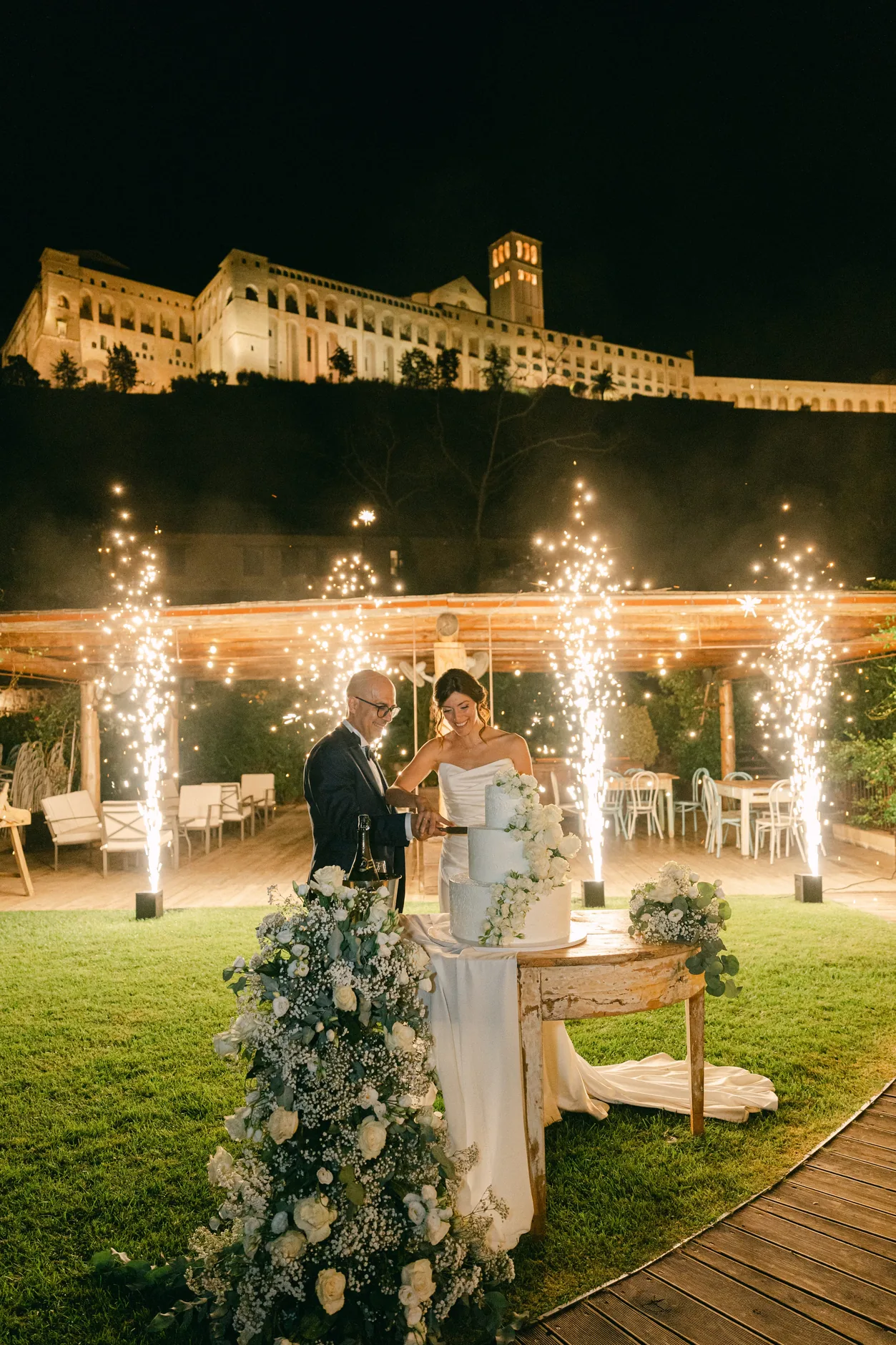 Il taglio della torta di sera tra le fontane luminose, con la Basilica illuminata sullo sfondo