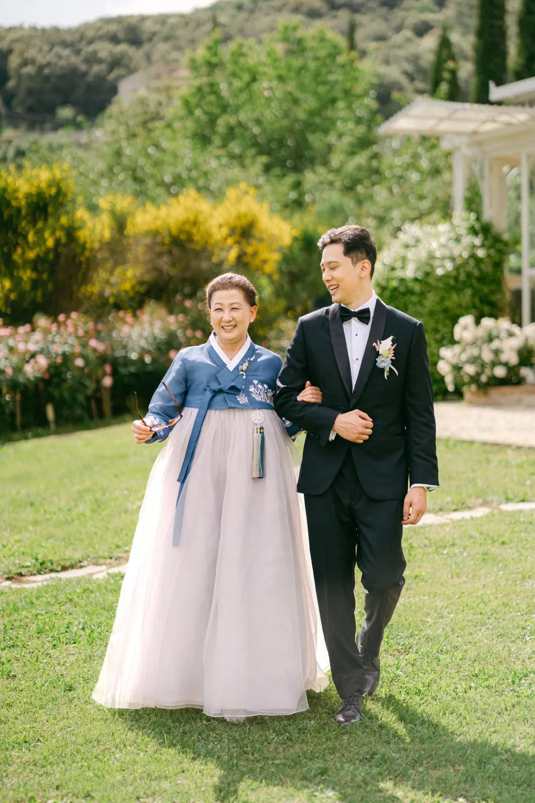 La madre di James in hanbok accompagna il figlio lungo il prato