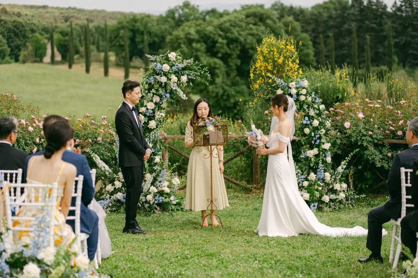 La cerimonia in giardino davanti all'arco di fiori, con la campagna di Amelia sullo sfondo