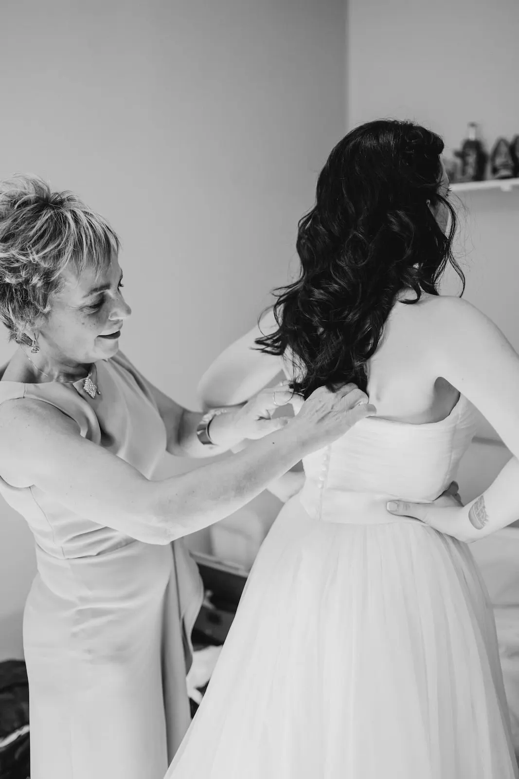 Valentina being helped into her dress, in black and white