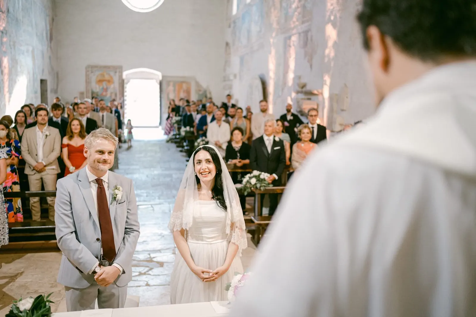 The couple standing at the altar, with the guests behind them
