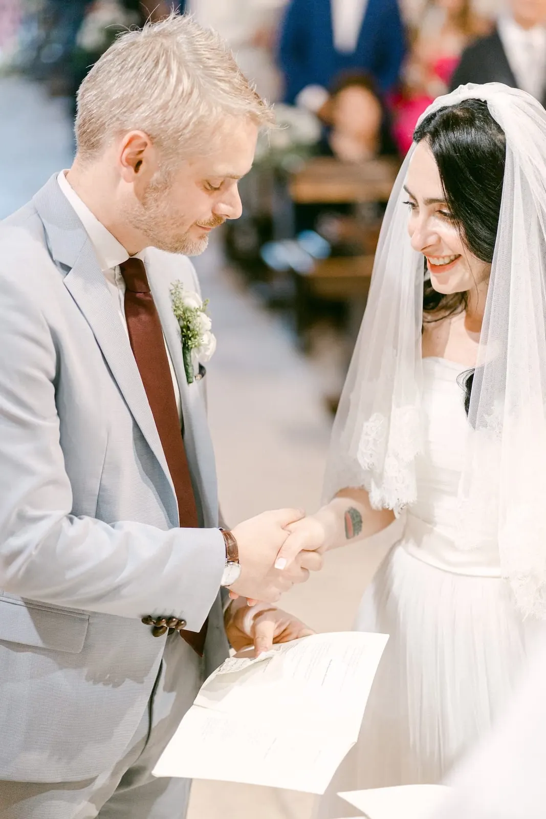 Valentina laughing as Thomas holds her hands during the service