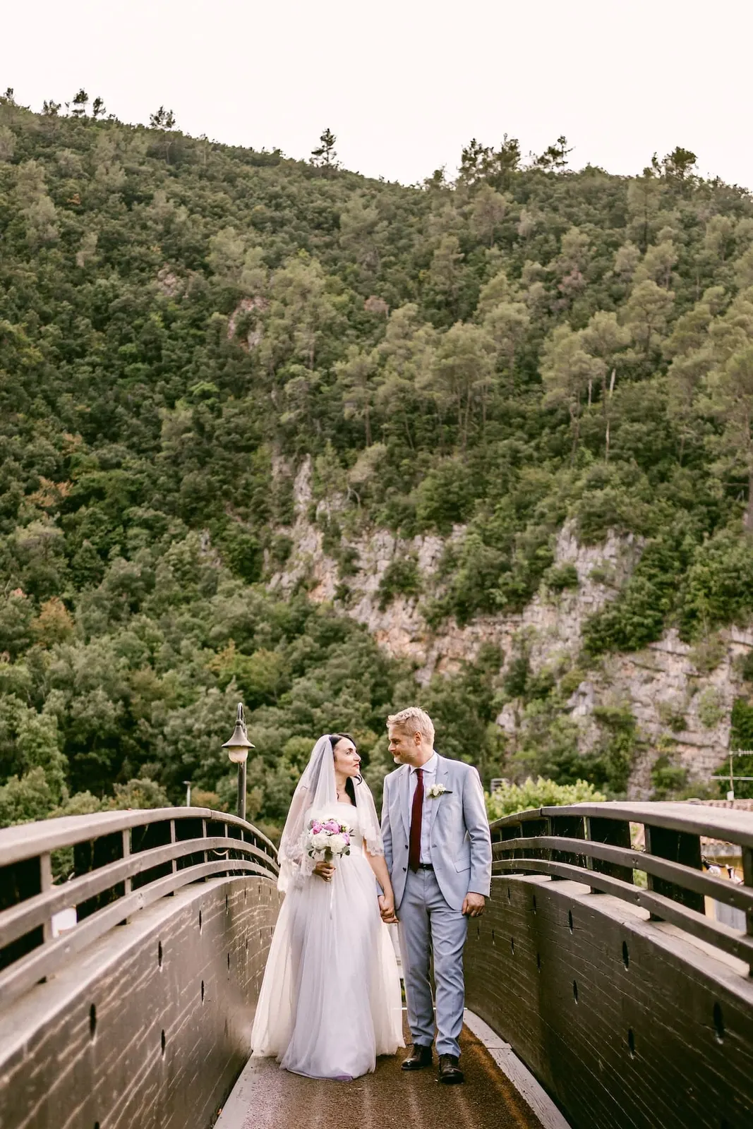 The couple on the wooden bridge, with the woods of the Valnerina behind them