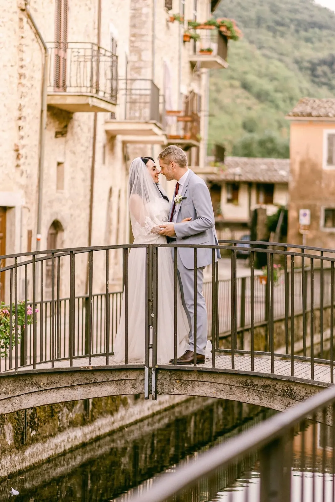 The couple kissing on a small bridge among the stone houses of the village