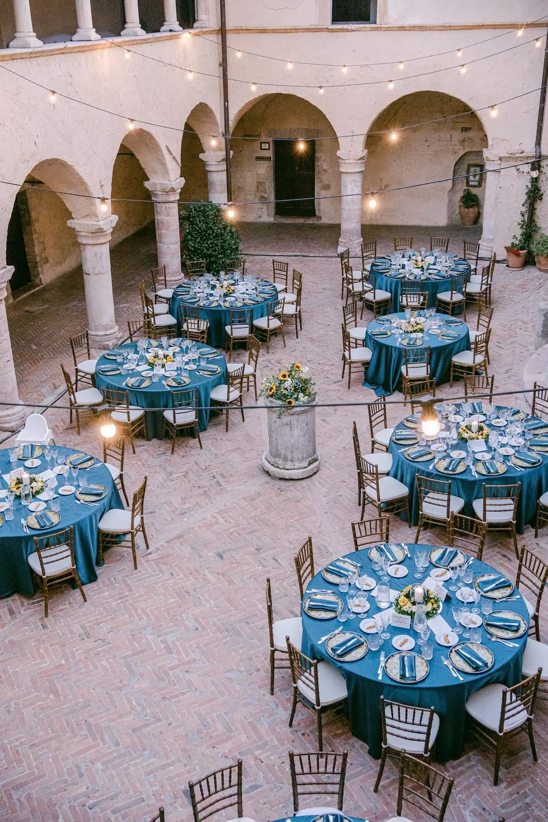 The abbey cloister seen from above, with round tables and string lights