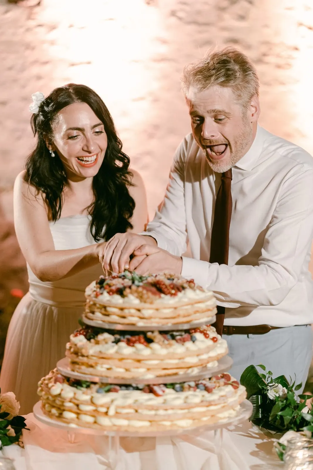 The couple laughing as they cut the millefoglie