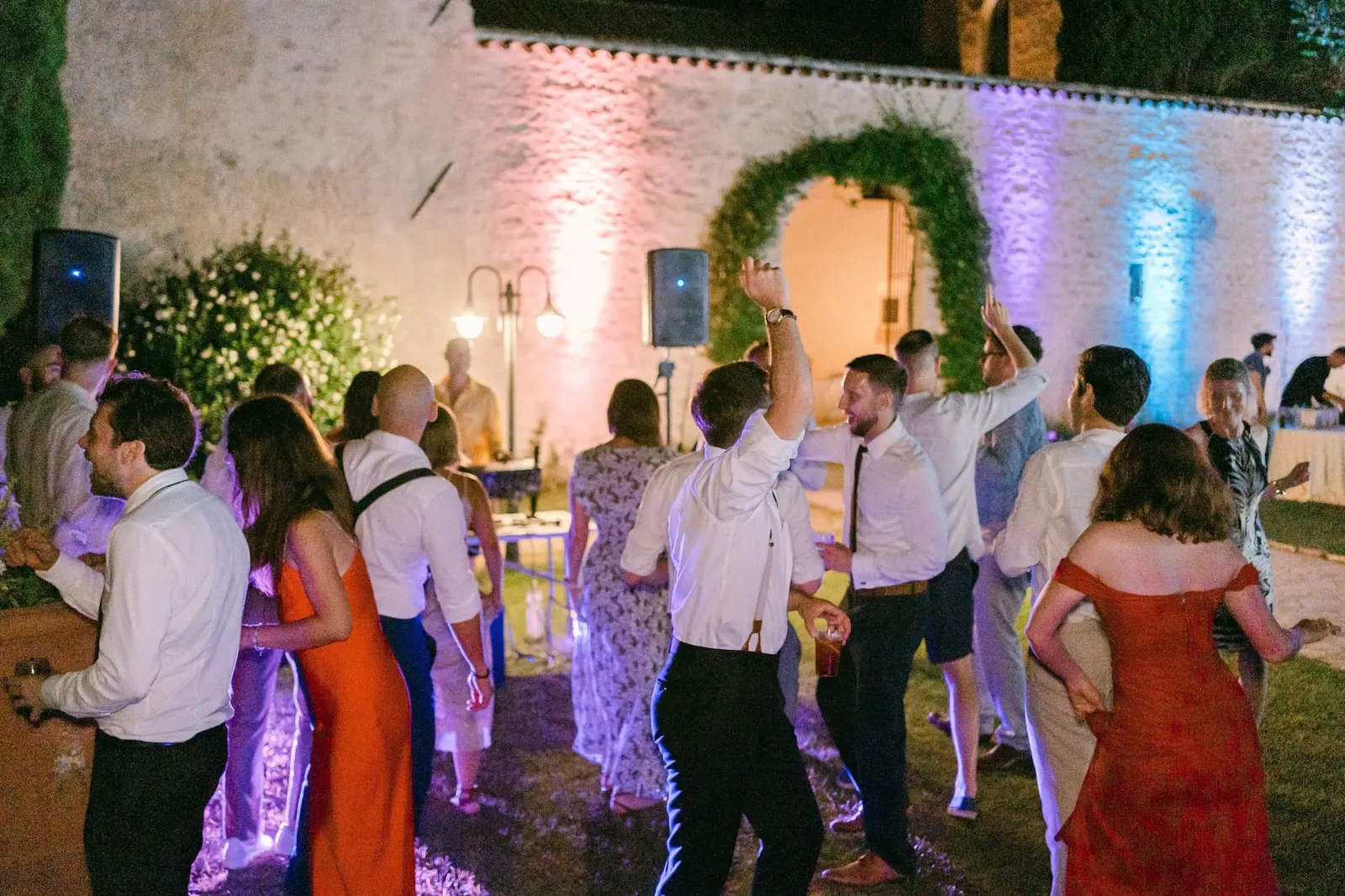 The outdoor party with coloured lights on the abbey wall
