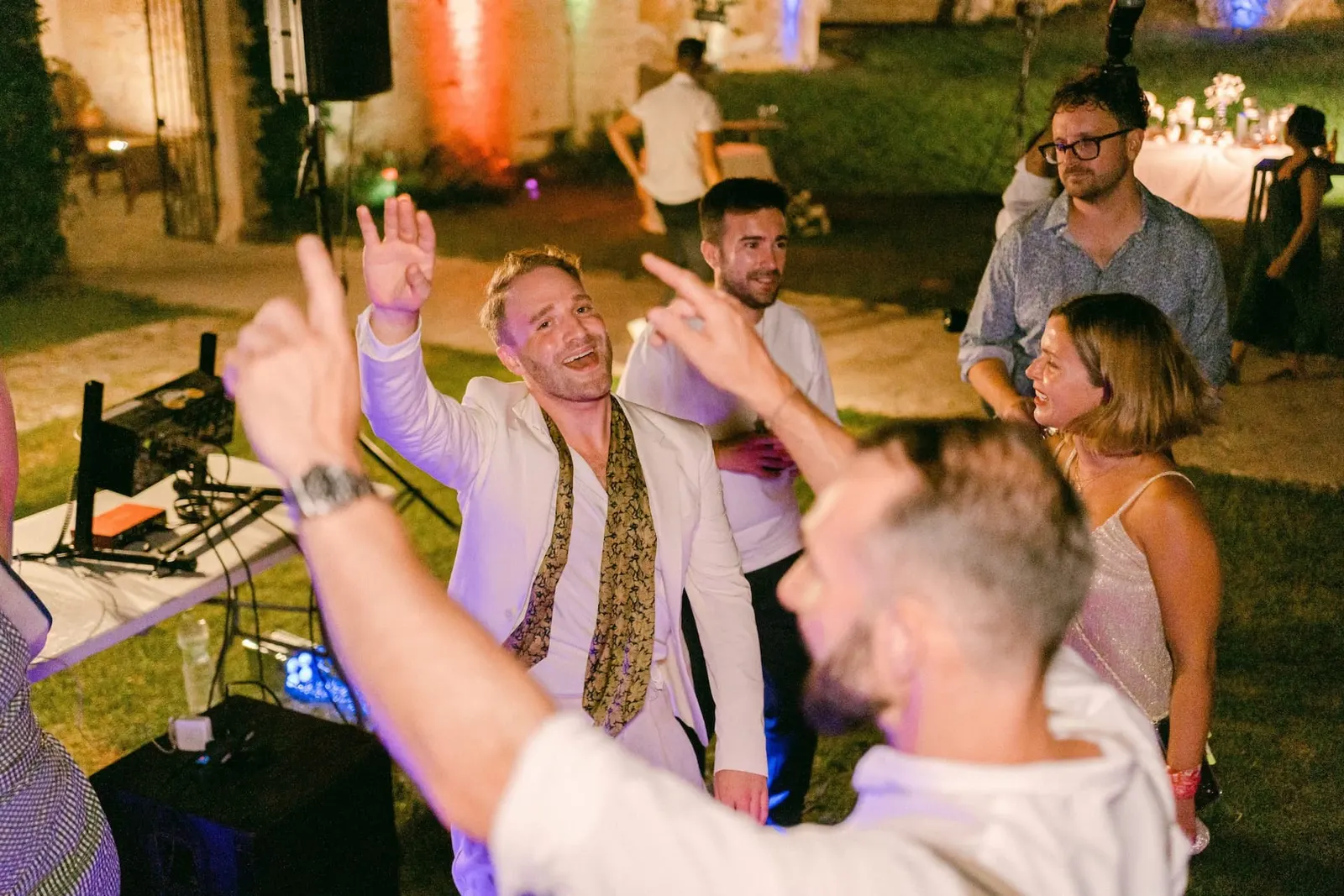 Guests dancing with their arms raised during the party