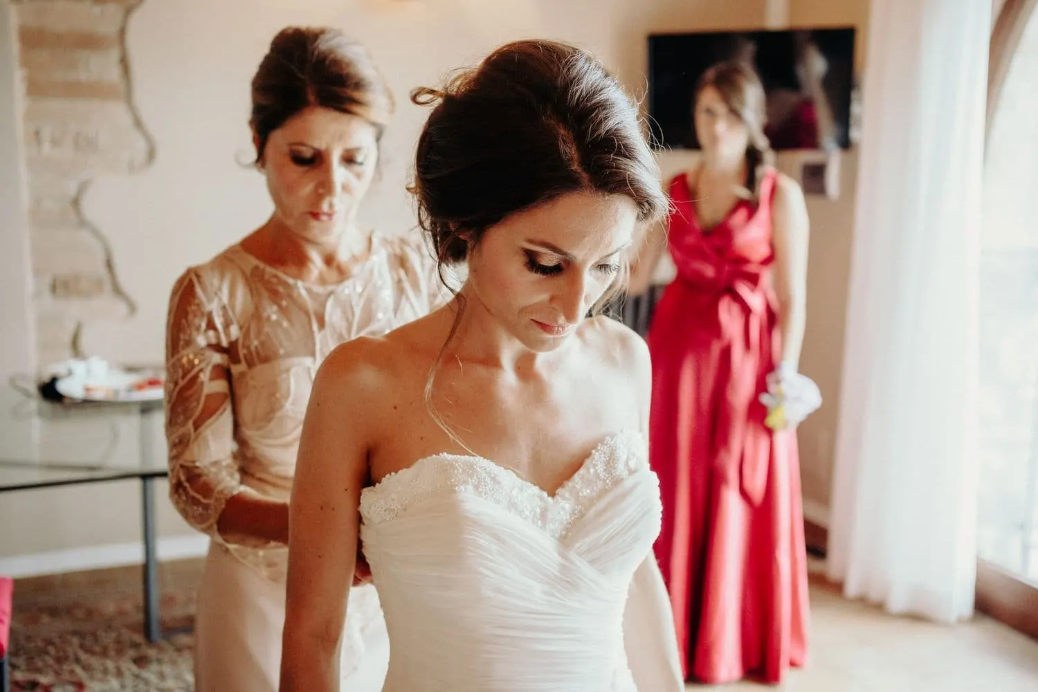 Giulia being helped to fasten her dress