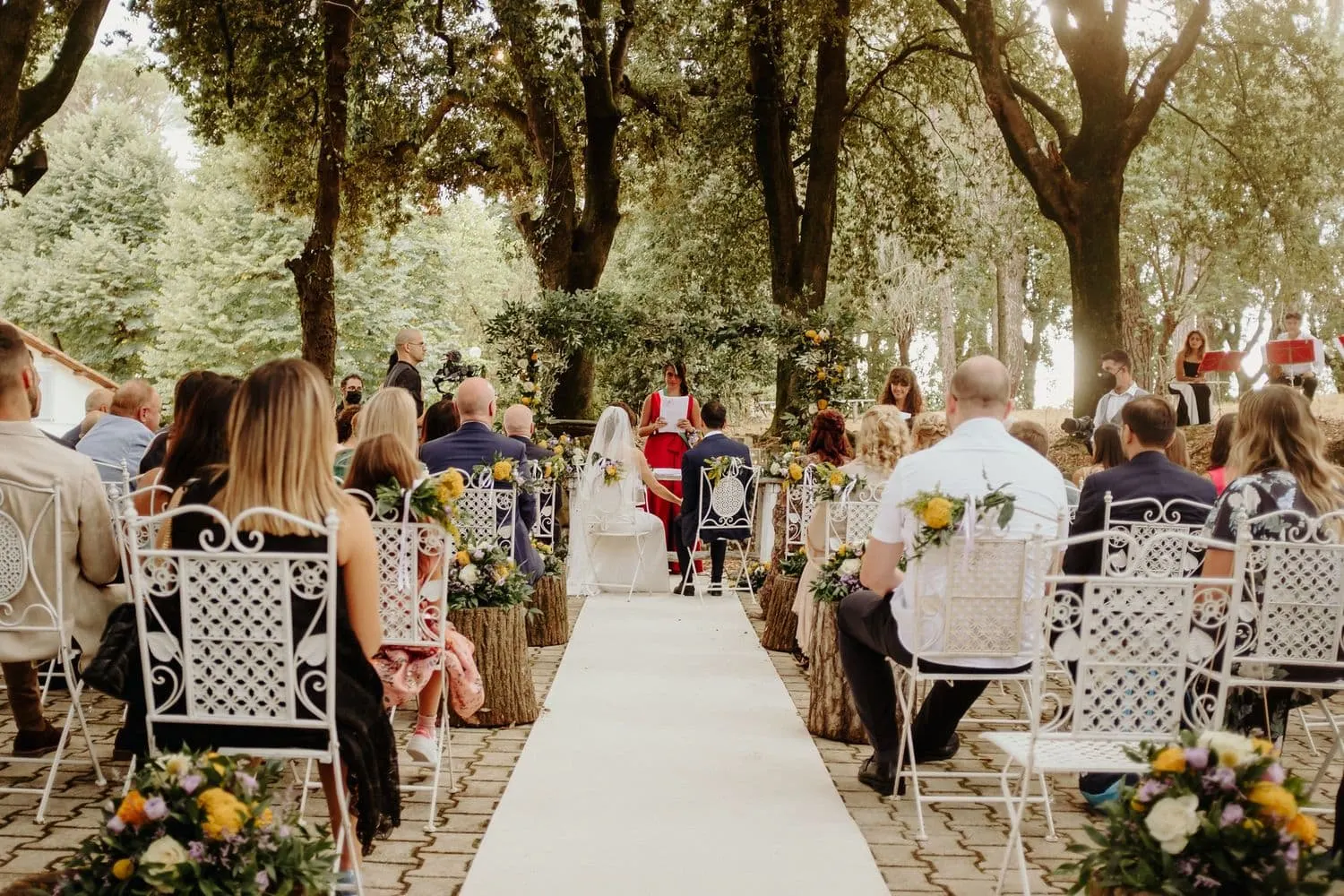 The ceremony seen from the end of the aisle, under the trees