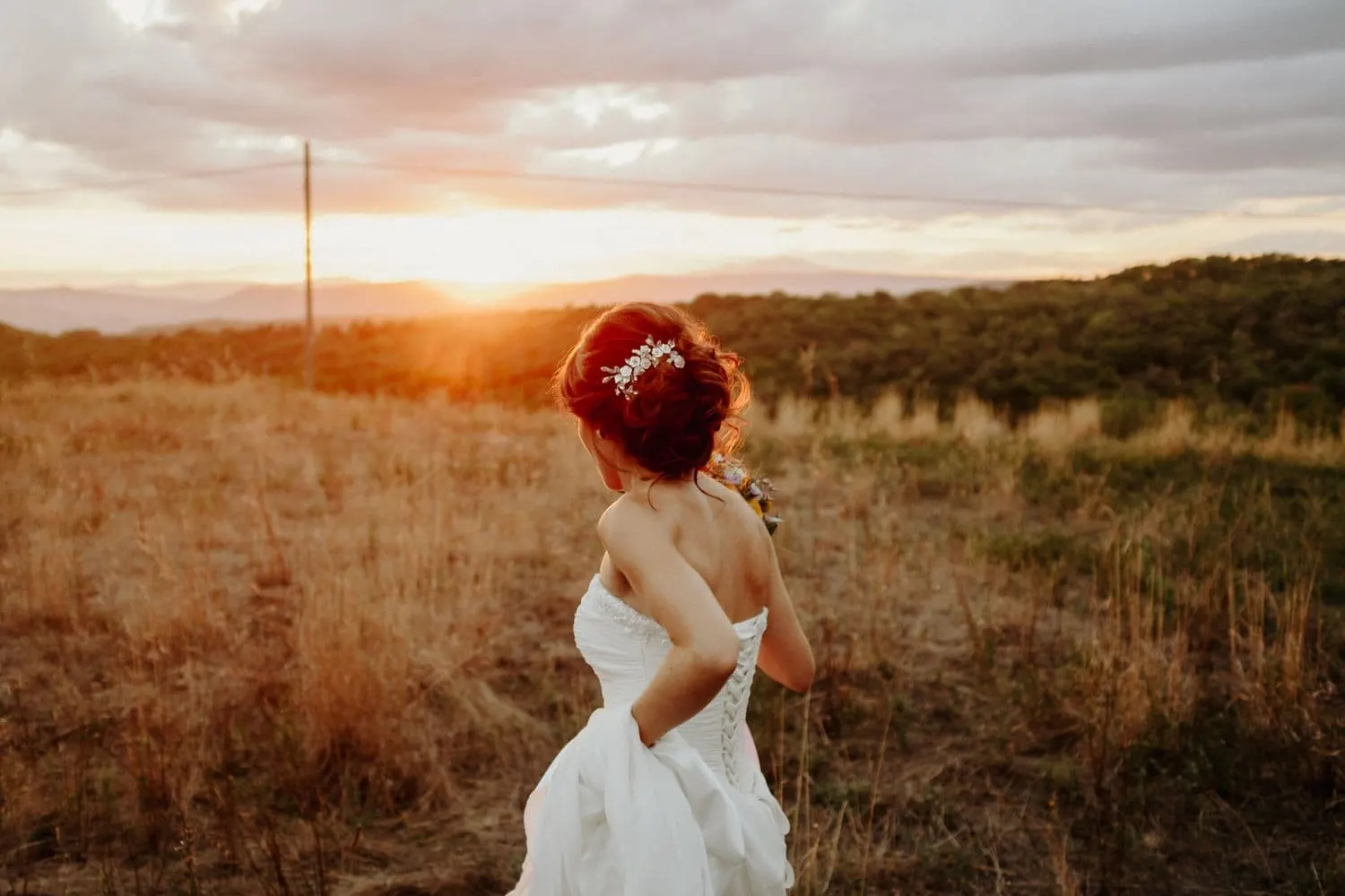 Giulia seen from behind, watching the sunset over the countryside around Orvieto