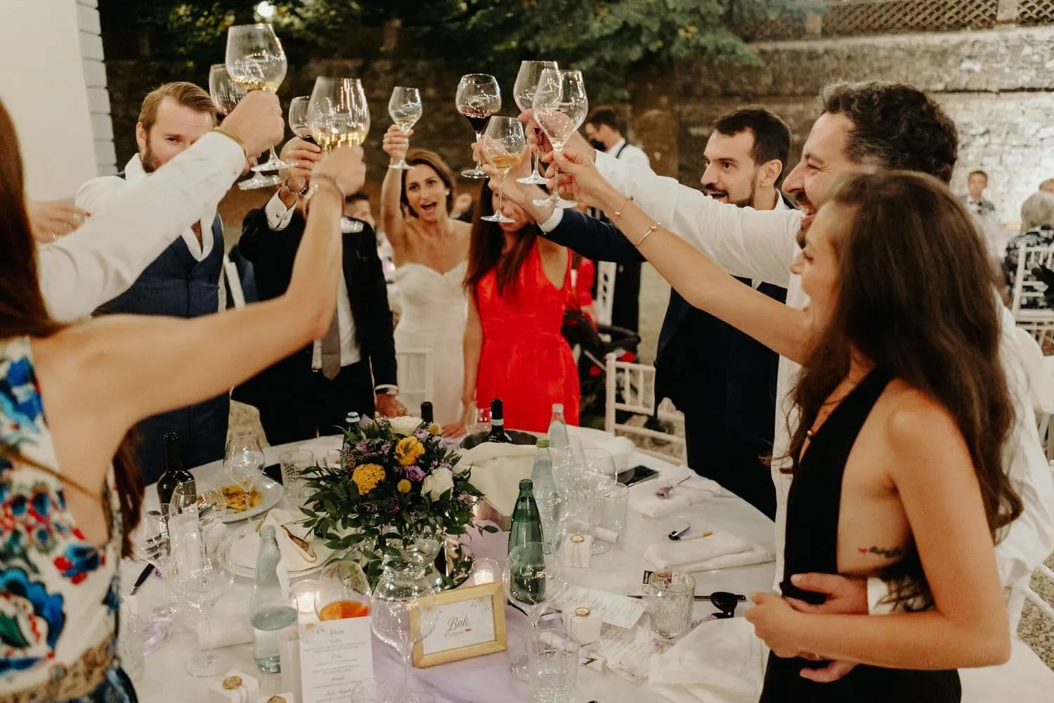 Glasses raised at a table during the outdoor dinner