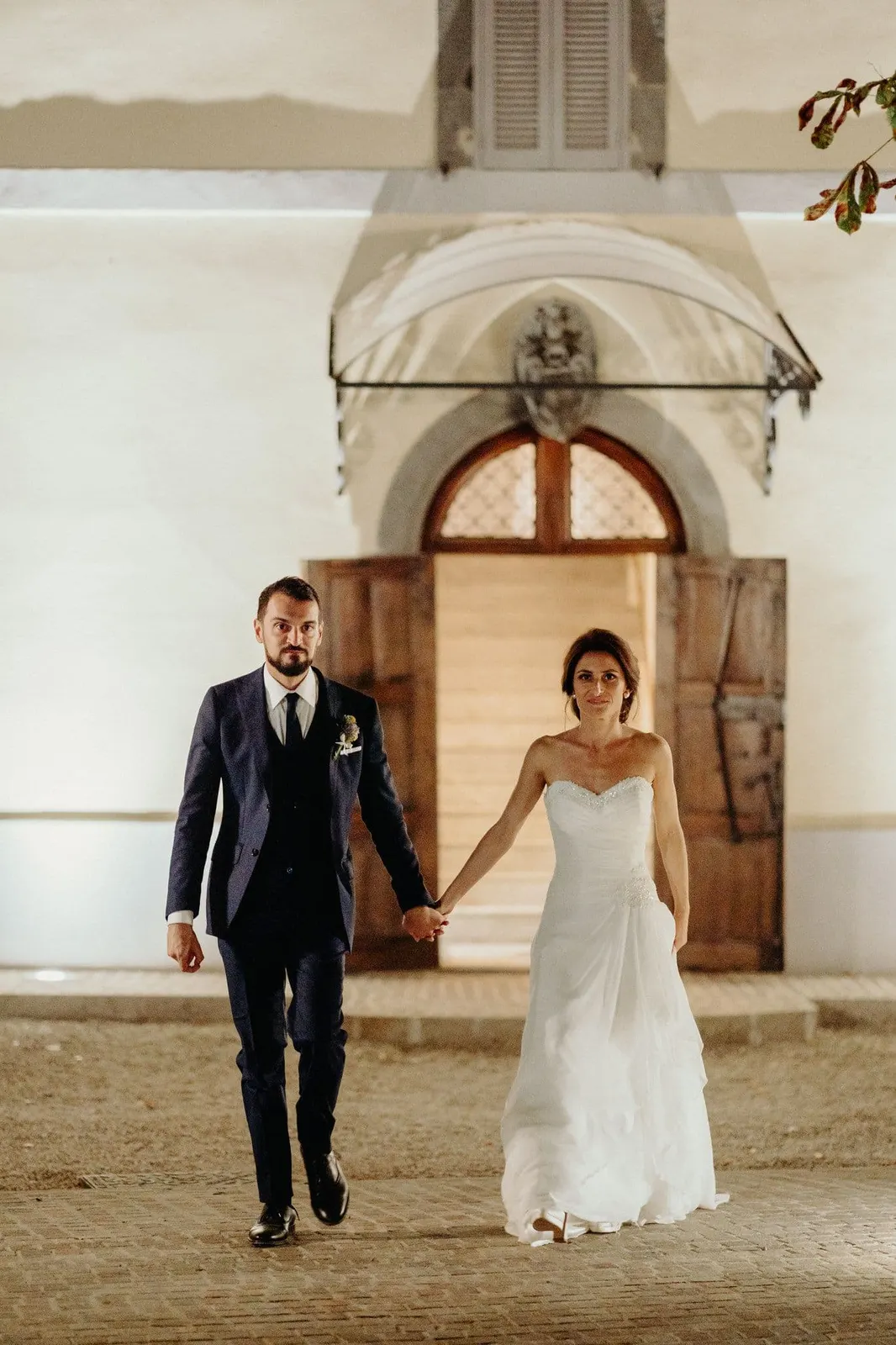 The couple walking hand in hand in front of the villa door, in the evening